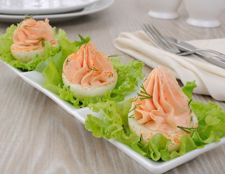Eggs stuffed with pate salmon with red pepper in lettuce leaves