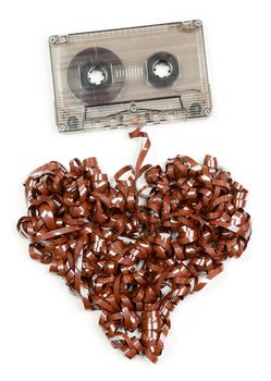 Vintage transparent Compact Cassette with pulled out tape in the shape of heart on white background