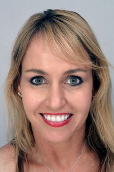 Studio close-up of a lovely blonde with a captivating smile.