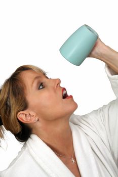 A lovely blonde turns her coffee cup upside-down with a disappointed or frustrated facial expression.  Isolated on a white background.