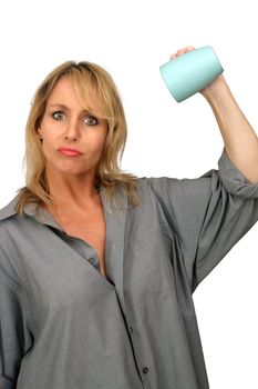 A lovely blonde turns her coffee cup upside-down with a disappointed or frustrated facial expression.  Isolated on a white background.