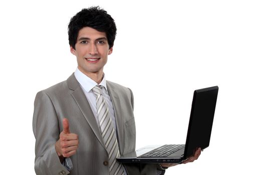 businessman holding a laptop and making a thumbs up sign
