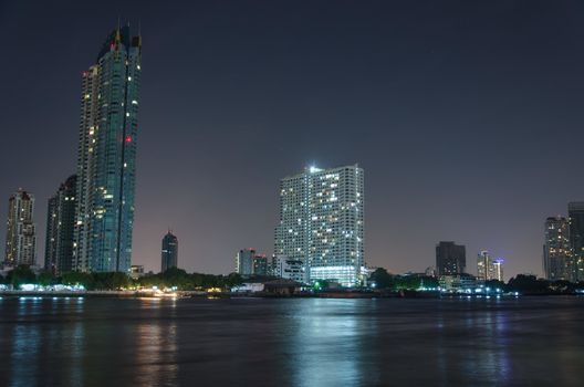 Riverside buildings at night in Bangkok, Thailand.