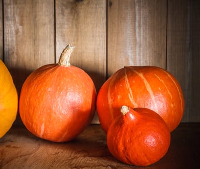 Pumpkins on grunge wooden backdrop, background table. Autumn, halloween, pumpkin, copyspace