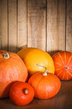 Pumpkins on grunge wooden backdrop, background table. Autumn, halloween, pumpkin, copyspace