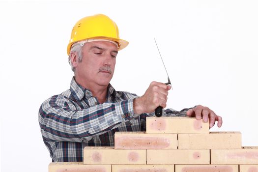 A mature mason building a wall.