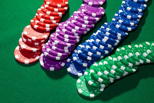 Colorful poker chips closeup on green cloth