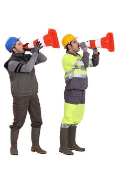 Men using traffic cones as loudspeakers