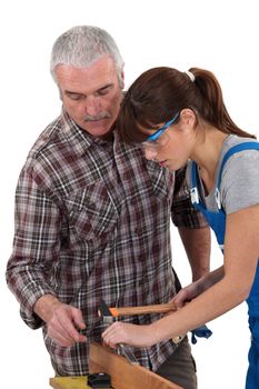 Carpenter teaching young female apprentice