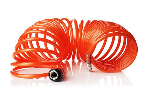 Orange red thin spiral air hose used for pneumatic tools. Isolated on white with natural reflection.