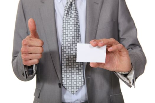 Businessman giving the thumbs up as her displays business card