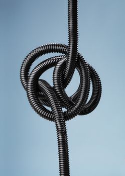 Tangled black flexible air hose.