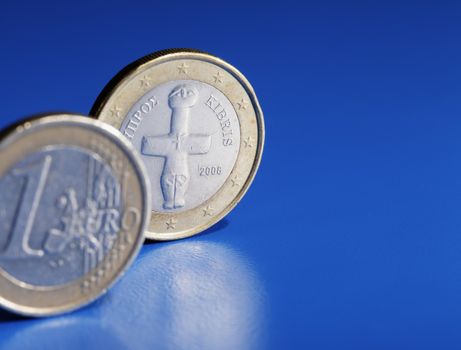 Euro coins from Cyprus on blue background.