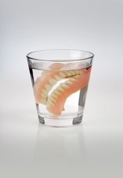 Old dentures in a glass of water.