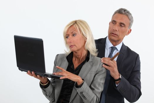 businessman and businesswoman analyzing information on their laptop