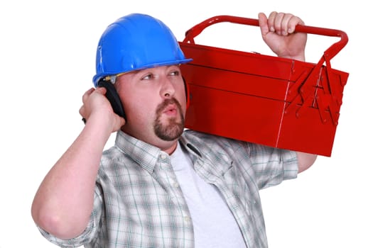 craftsman wearing headphones and carrying a tool box