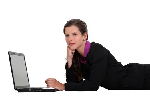 Businesswoman lying down with a laptop