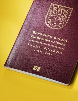 Finnish (Finland) passport on yellow background. This is the new (2013) design of the passport