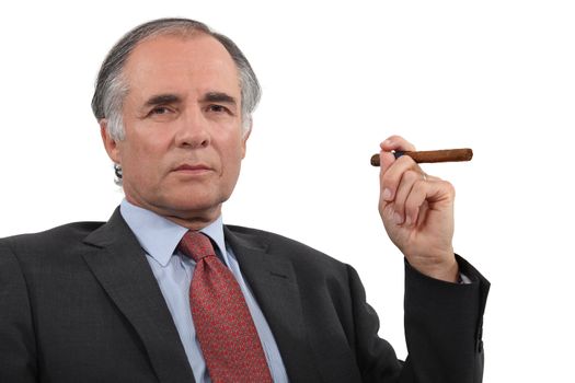 A mature businessman smoking a cigar.