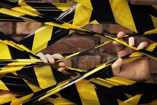 A Person behind yellow and black barrier tape.