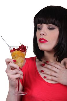 Woman holding glass of fruits salad