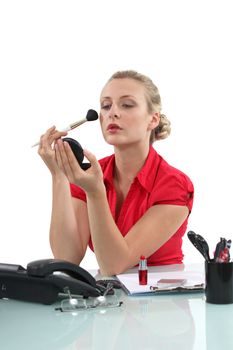 Office worker applying make-up
