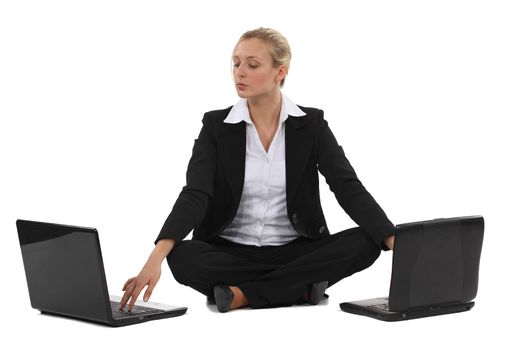 Blond businesswoman sat with two laptops