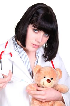 Doctor administering an injection to a teddy bear