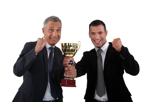 cheerful businessmen holding a golden cup