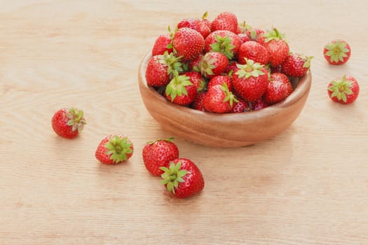 Old Wooden Bowl Filled With Succulent Juicy Fresh Ripe Red Strawberries On An Old Table top