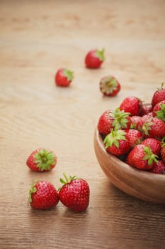 Old Wooden Bowl Filled With Succulent Juicy Fresh Ripe Red Strawberries On An Old Table top