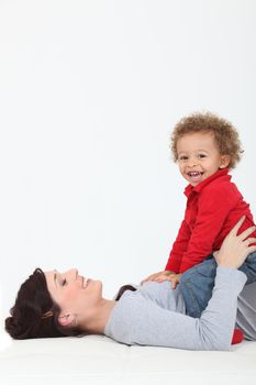 Mother resting son on belly