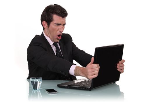 Furious businessman in front of his laptop