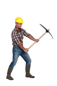 Building worker using a pickaxe, studio shot