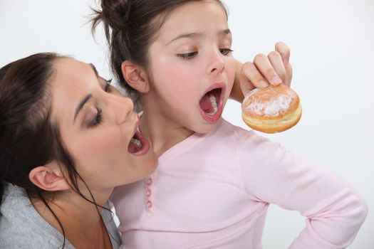 Mother and daughter sharing doughnut