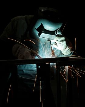 human working of welding with a lot of sparks in a metal industry factory