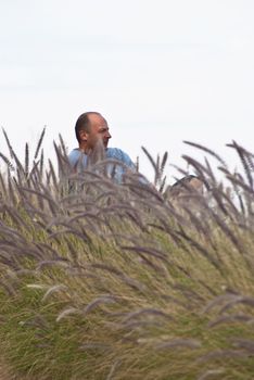 Portrait of handsome man sitting in a field of wheat