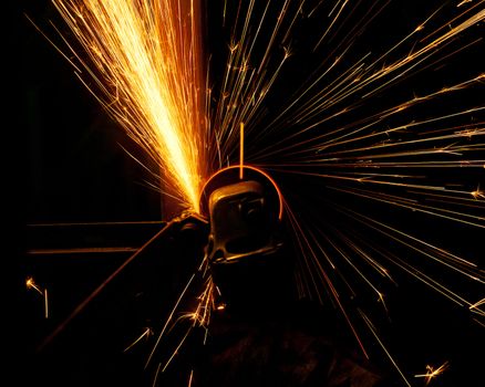 Worker cutting metal with grinder