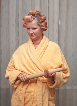 Young woman in a dressing gown with a rolling pin.