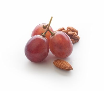 Three berries of grape, walnut and almond on the white background