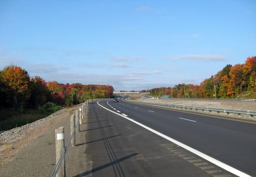 Highway in fall time under blue sky
