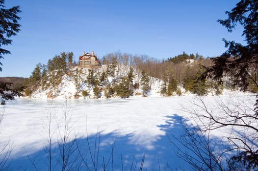 Lone cottage on stone Lac Meech shore in winter
