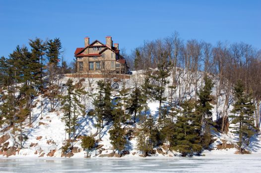 Lone cottage on stone lake shore