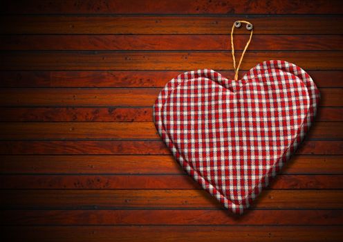 Handmade clothe heart hanging on brown wooden background