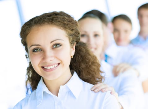 portrait of a young business woman standing in line with colleagues, concept of teamwork