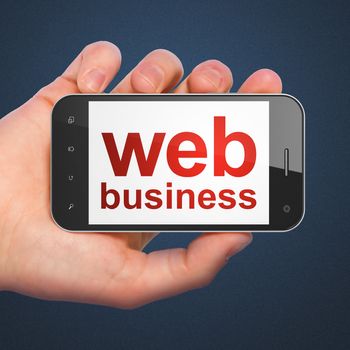 SEO web development concept: hand holding smartphone with word Web Business on display on Dark Blue background.