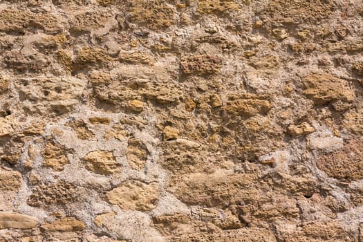 Old wall made of the Jerusalem stone. Wall constructed of stone bricks.