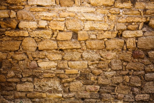Old wall made of the Jerusalem stone. Wall constructed of stone bricks.