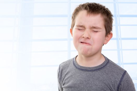 Eight years old kid feeling the pain that shows with his facial expression