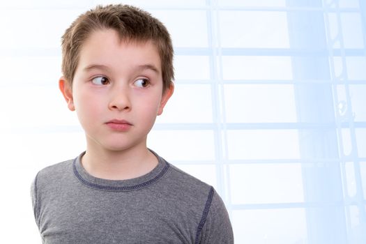 Eight years old kid looking out skeptically accusing with his big eyes